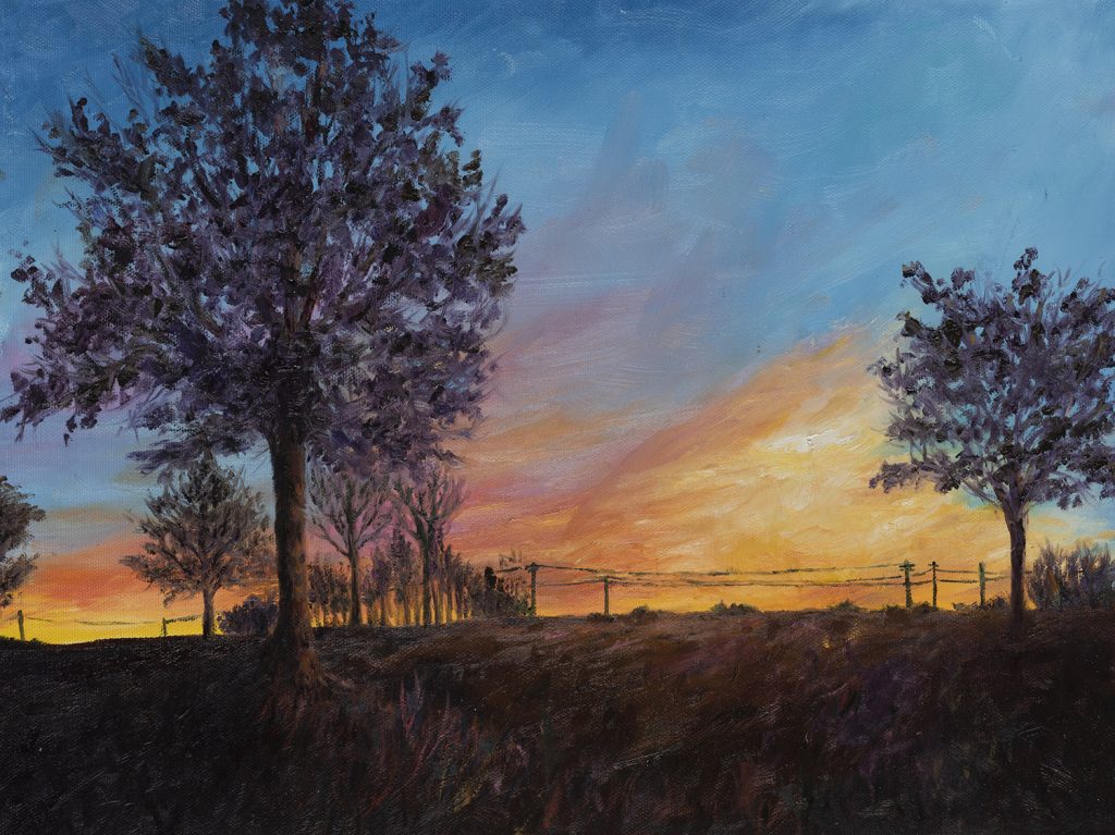 sunset with dark trees and power lines against bight orange and yellow clouds
